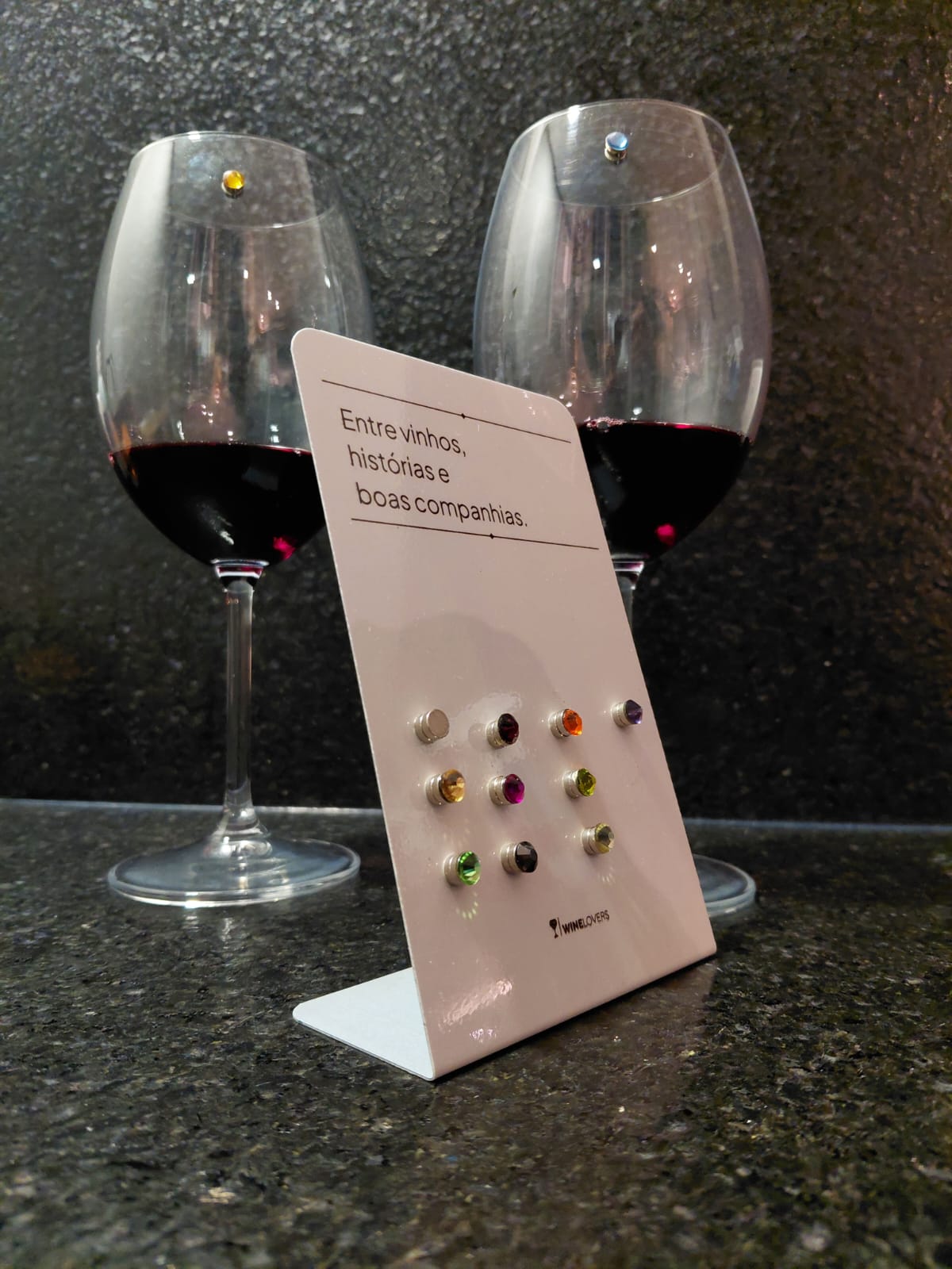 Chapa WineLovers com marcadores coloridos e taças de vinho ao fundo